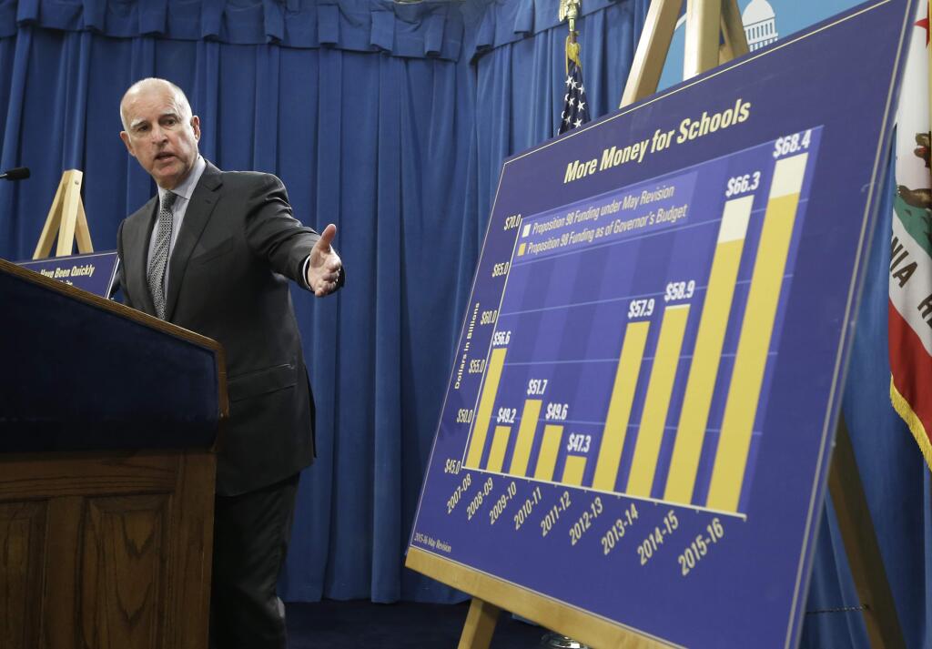 Gov. Jerry Brown gestures to a chart showing the increase in education spending as he discusses his revised state budget plan during a news conference Thursday in Sacramento.(RICH PEDRONCELLI / Associated Press)