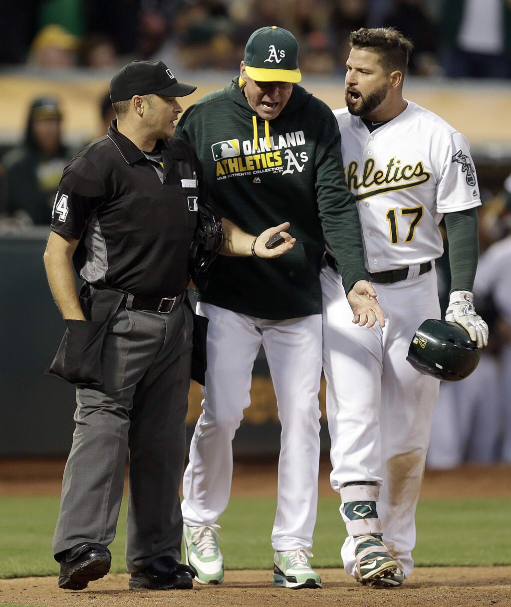Oakland Athletics manager Bob Melvin, center, and Athletics' Yonder Alonso (17) argue with home plate umpire Mark Wegner after being ejected during the fourth inning of a baseball game Friday, July 15, 2016, in Oakland, Calif. (AP Photo/Ben Margot)