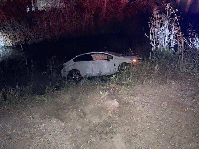 A white Honda Civic rests in Lichau Creek. Police found the vehicle there when responding to a crash that killed one driver. The Honda’s driver was arrested on suspicion of DUI after police say his car crossed into ongoing traffic and struck a pickup.