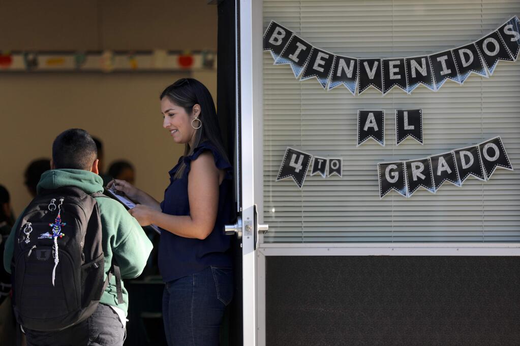 Fourth-grade teacher Raquel Figueroa welcomes students during the first day of class at Cesar Chavez Language Academy on the Lawrence Cook Middle School campus in Santa Rosa on Wednesday, Aug. 14, 2019. (Beth Schlanker / The Press Democrat)