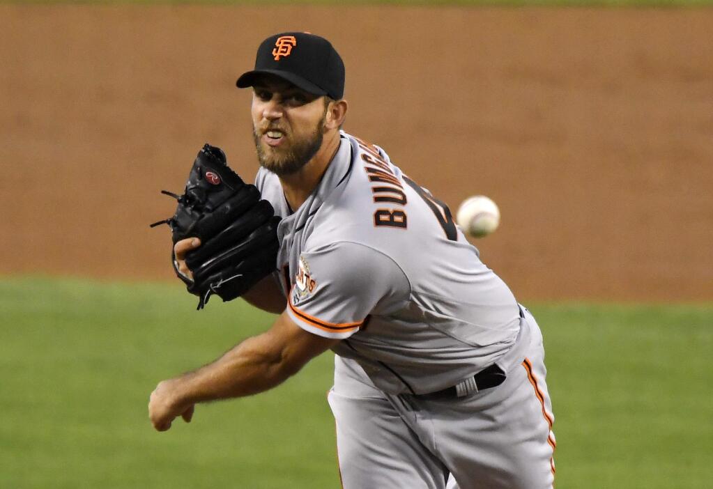 San Francisco Giants starting pitcher Madison Bumgarner watches a throw during the first inning of a baseball game against the Los Angeles Dodgers, Tuesday, Aug. 23, 2016, in Los Angeles. (AP Photo/Mark J. Terrill)