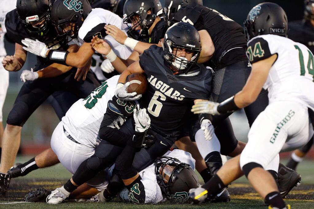 Windsor running back Lorenzo Leon (6), center, fights to stay on his feet while running through the Casa Grande defense, during the first half of a varsity football game between Casa Grande and Windsor high schools in Windsor, California, on Friday, August 17, 2018. (Alvin Jornada / The Press Democrat)
