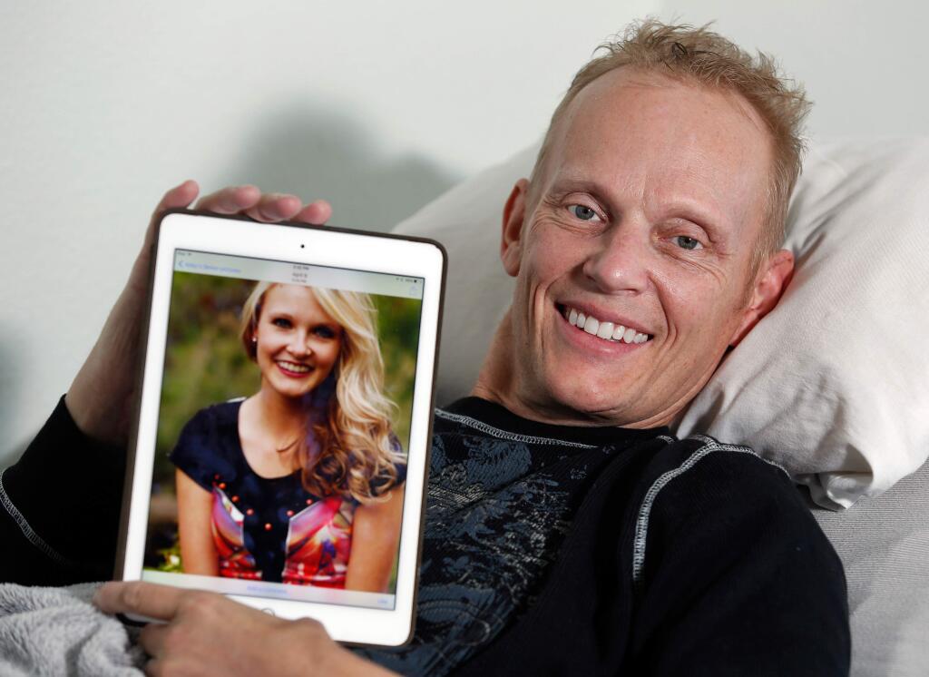 Richard Anderson poses for a portrait with a photograph of his daughter Abby, 18, at his home in Cloverdale, California on Thursday, November 12, 2015. Currently recuperating and undergoing physical therapy, Richard and Abby were critically injured in an August car crash in Geyeserville that killed two people. (Alvin Jornada / The Press Democrat)