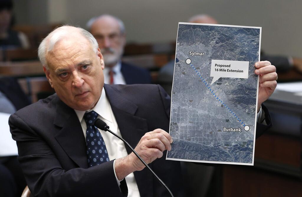 FILE - In this Jan. 27, 2016, file photo, Dan Richard, chairman of the board that oversees the California High Speed Rail Authority, displays a map showing the proposed extension of the rail project to Burbank, during a legislative hearing in Sacramento, Calif. Gov. Jerry Brown has reappointed two leaders of California's embattled high-speed rail board days before leaving office. Brown on Wednesday, Jan. 2, 2019, gave Dan Richard and Tom Richards new four-year terms. They serve as chairman and vice chairman, respectively, of the California High-Speed Rail Authority's board of directors. (AP Photo/Rich Pedroncelli, File)
