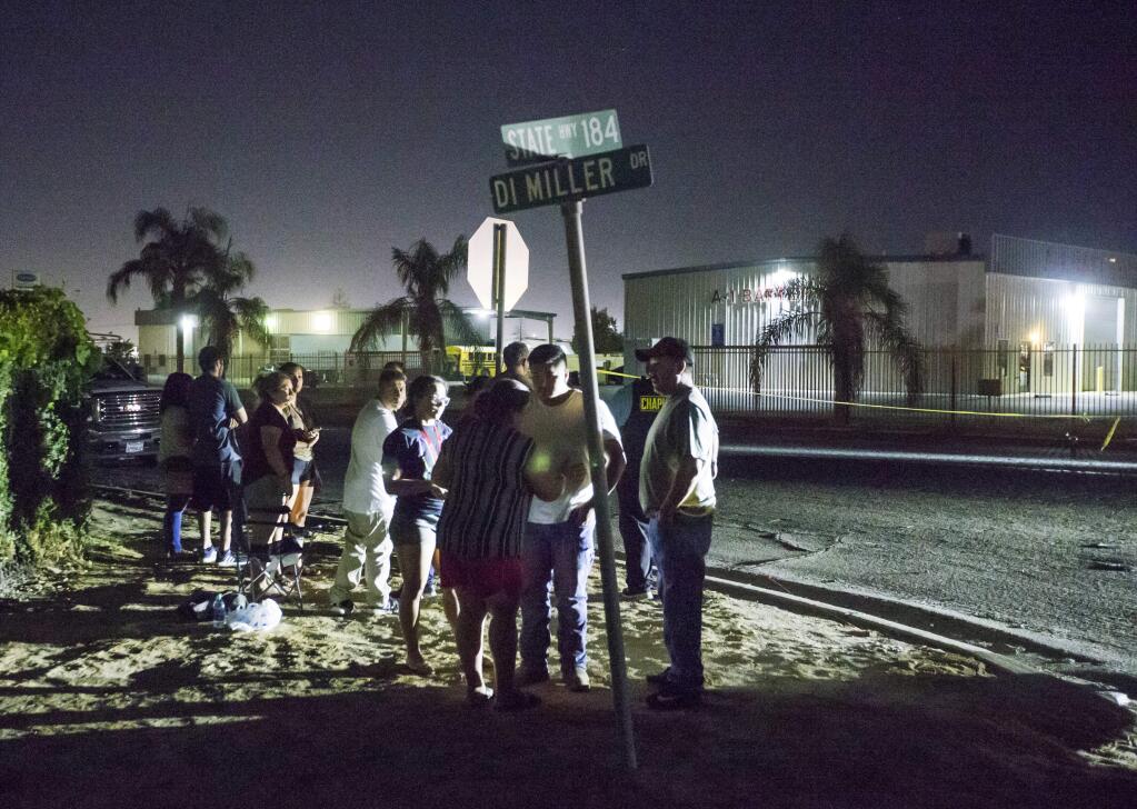 A crowd gathers near a location where a gunman opened fire, killing several people, Wednesday, Sept. 12, 2018, in Bakersfield, Calif. A gunman killed five people, including his wife, before turning the gun on himself, authorities said. (Felix Adamo/The Bakersfield Californian via AP)