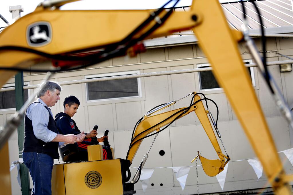 Randy Bryson, a business representative with Operating Engineers Local No 3., instructs Jerardo Herrera, 11, from Brook Hill Elementary School, how to use a backhoe simulator during the Santa Rosa City Schools College & Career Day at the Hall of Flowers on the Sonoma County Fairgrounds on Thursday, March 12, 2015. (BETH SCHLANKER/ The Press Democrat)