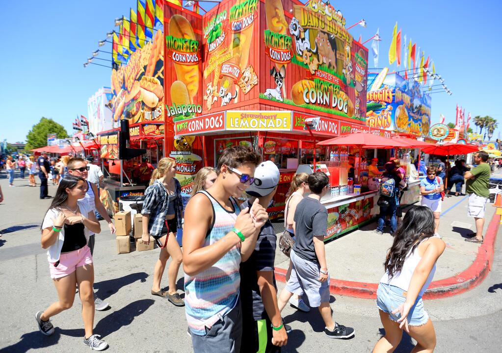 Teens turn the corner on the food vender road at the Sonoma County Fair, Wednesday July 30, 2014 in Santa Rosa. (Kent Porter / Press Democrat) 2014
