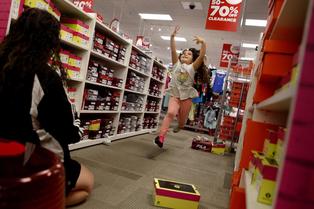 Arianna Garcia, 5, leaps in the air as she tries on shoes with her mom, Mandy Smith, while they do their back-to-school shopping at JCPenney in Santa Rosa, on Monday, August 8, 2016. Arianna will be a first grader at Spring Creek Elementary School.(BETH SCHLANKER/ The Press Democrat)