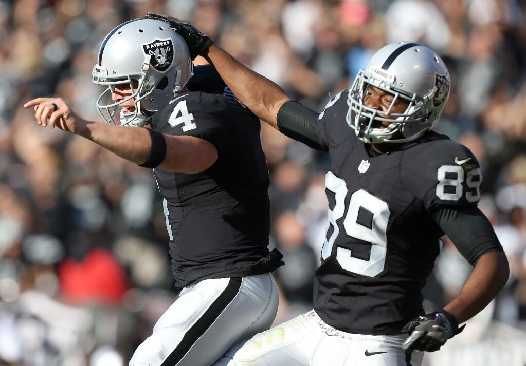 Oakland Raiders quarterback Derek Carr and wide receiver Amari Cooper celebrate connecting on a touchdown against the Tennessee Titans, during their game in Oakland on Saturday, August 27, 2016. (Christopher Chung/ The Press Democrat)