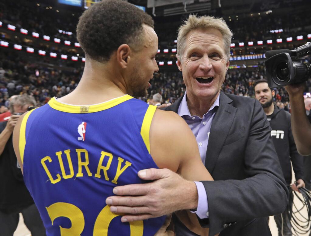 Golden State Warriors head coach Steve Kerr hugs Stephen Curry (30) after they take the lead in the final seconds of the second half against the Utah Jazz, Friday, Oct. 19, 2018, in Salt Lake City. (AP Photo/Rick Bowmer)