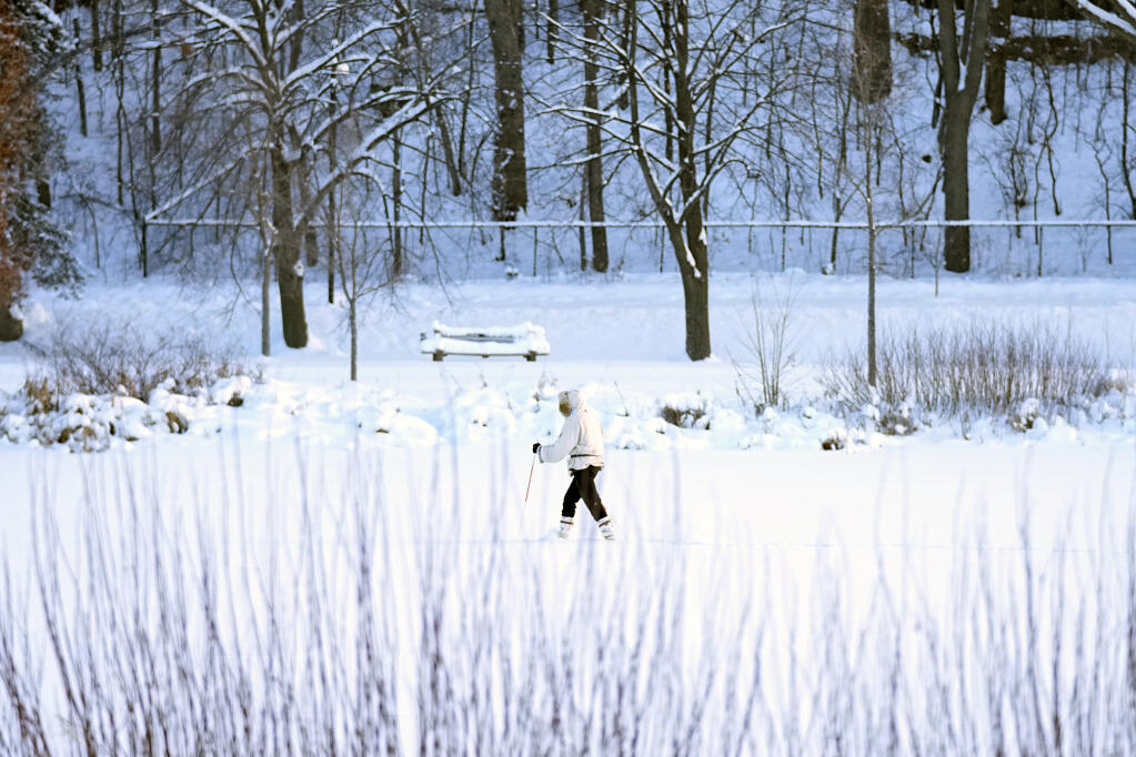 A skier makes her way across Lake of the Isles Thursday, Dec. 22, 2022, in Minneapolis. (AP Photo/Abbie Parr)