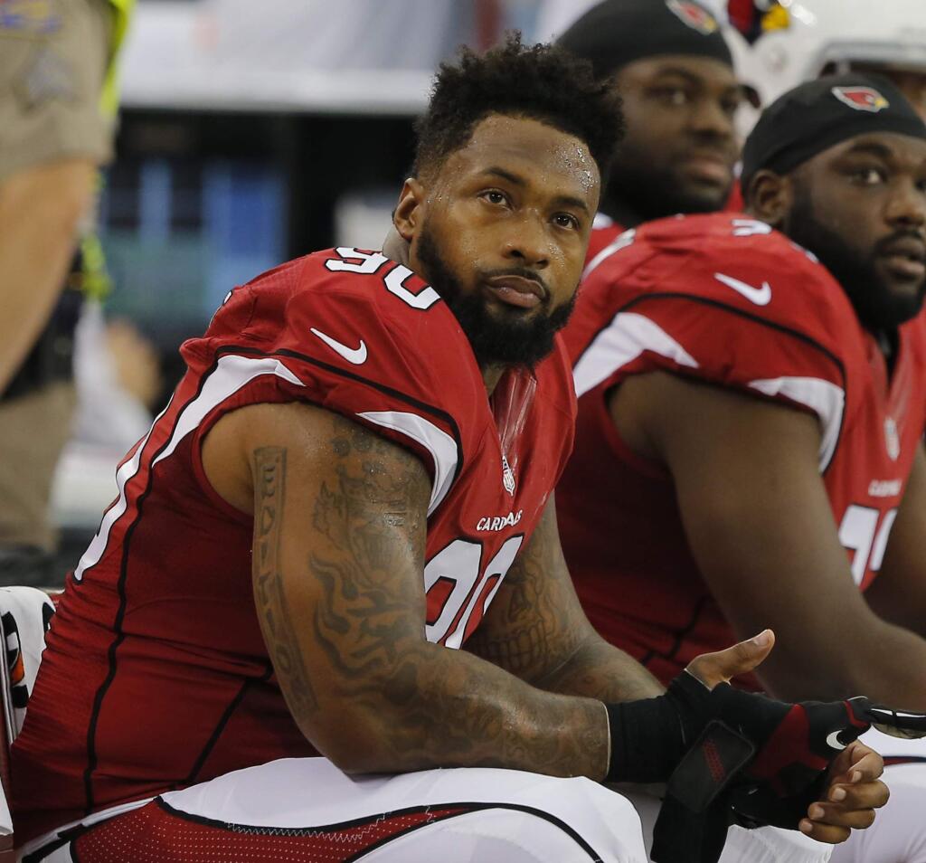 In this Aug. 9, 2014, file photo, Arizona Cardinals' Darnell Dockett sits on the sideline during the first quarter of an NFL football game in Glendale, Ariz. (AP Photo/Rick Scuteri, File)