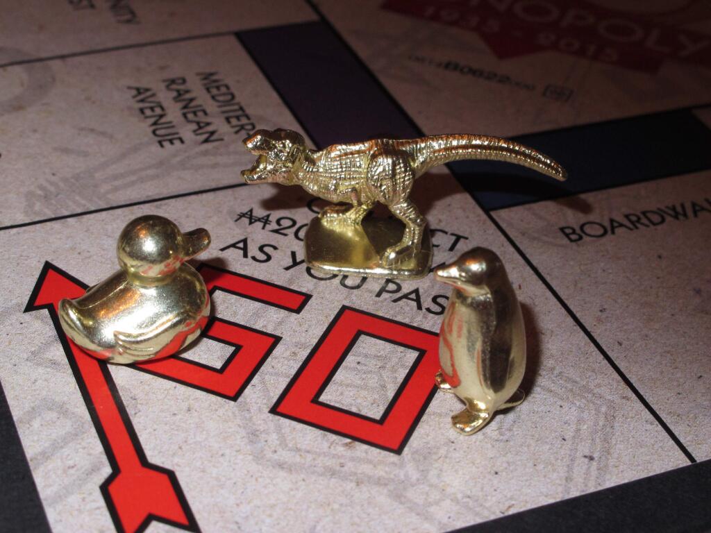 This March 15, 2017 photo shows the three new tokens in Atlantic City, N.J., that fans from around the world have voted into upcoming editions of the board game Monopoly: a duck, a T-Rex dinosaur and a penguin. Hasbro Inc. revealed the results of voting on Friday, March 17, 2017. Leaving the game will be the boot, wheelbarrow and thimble tokens. (AP Photo/Wayne Parry)