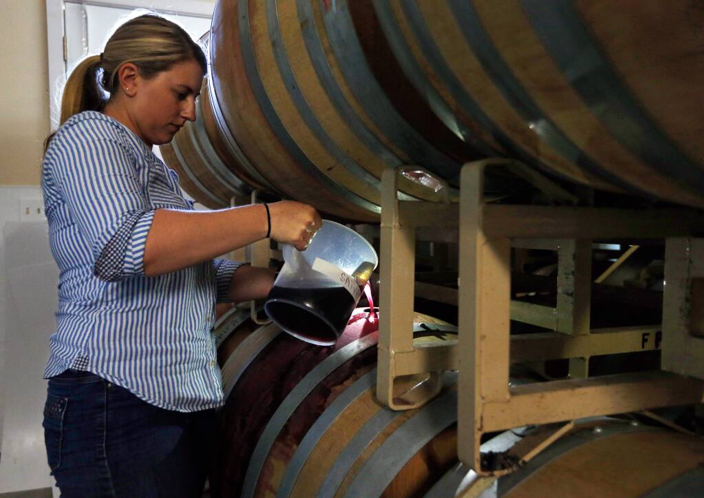 Winemaker Erica Stancliff tops off barrels of pinot noir at Furthermore Wines in Sebastopol on Monday, June 12, 2017. (ALVIN A.H. JORNADA/ The Press Democrat)