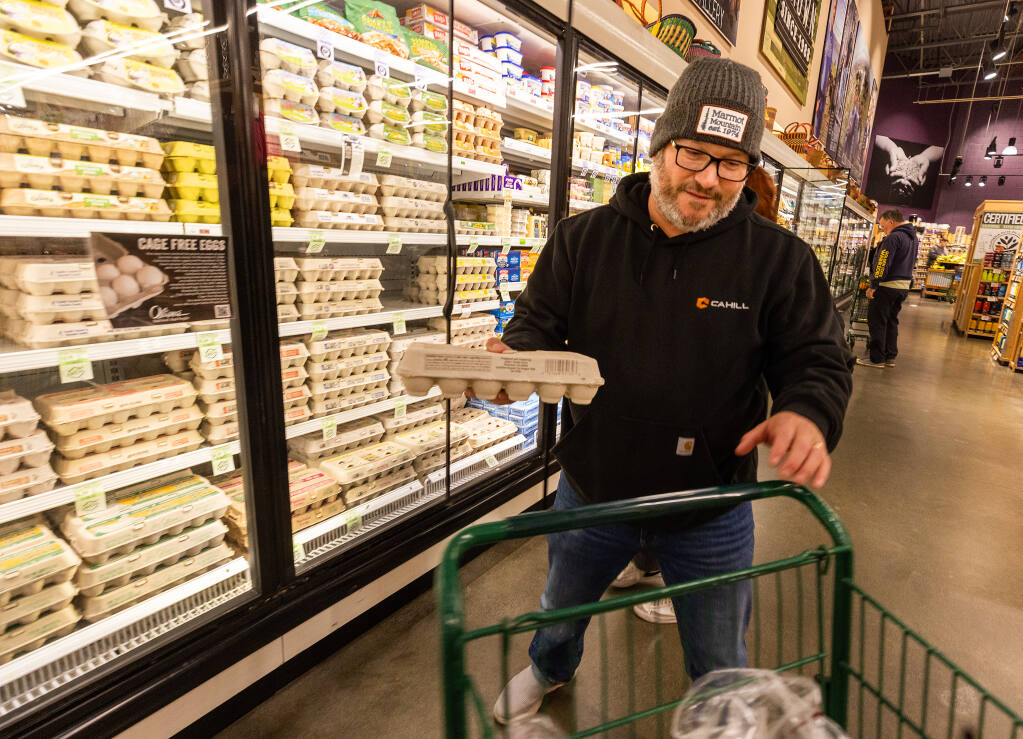Matt Bonfigli picks up a dozen eggs at Oliver’s Market in Windsor Wednesday, January 4, 2023.  In spite of a national egg shortage, the grocer maintains their supply using with local suppliers. (John Burgess/The Press Democrat)