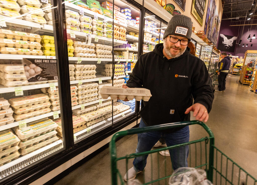 In this file photo taken earlier this year, Matt Bonfigli picks up a dozen eggs at Oliver’s Market in Windsor, when a national bird flu outbreak was wreaking havoc on egg prices. Local markets and restaurants say that while the current outbreak could affect prices, they do not expect to see significant issues. (John Burgess / The Press Democrat)