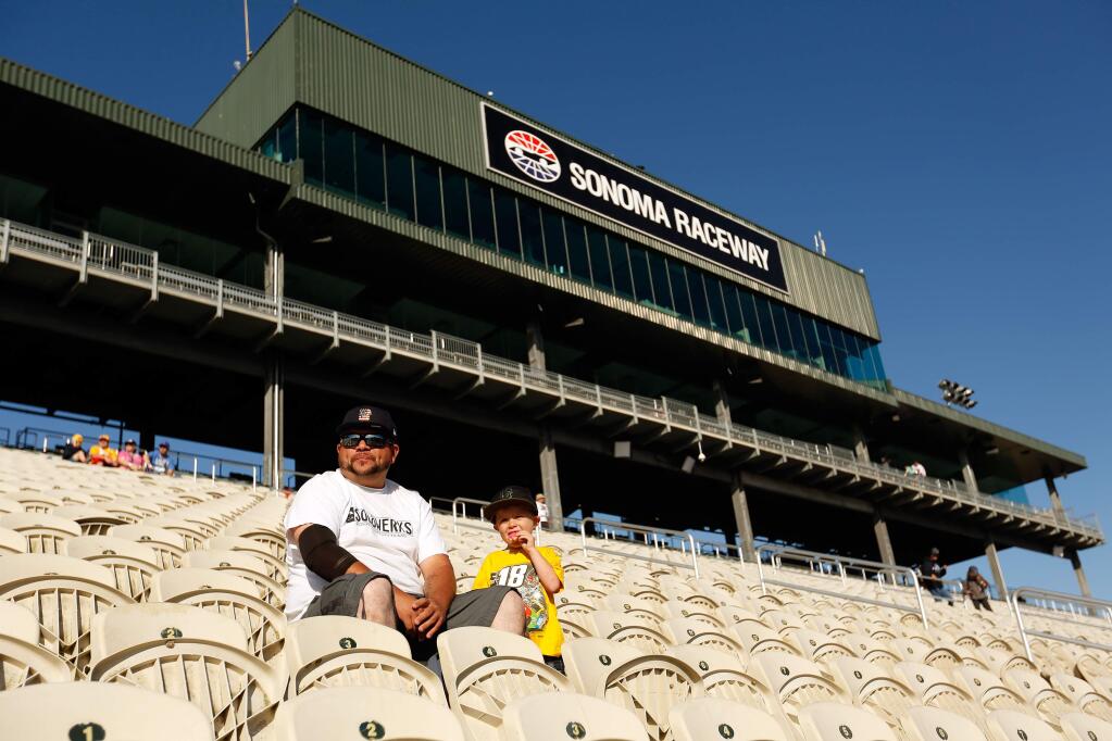 Anthony Estupinan of Santa Rosa and his son Enzo, 4, arrive early to watch pre-race activities before the Monster Energy NASCAR Cup Series Toyota/Save Mart 350 race at Sonoma Raceway on Sunday, June 24, 2018. (Alvin Jornada / The Press Democrat)