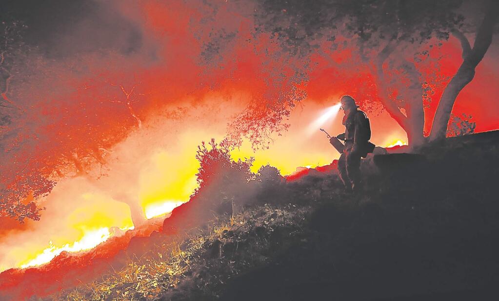 A Cal Fire firefighter monitors a flare-up at the head of the Nuns fire off High Road above the Sonoma Valley on Wednesday Oct. 11, 2017. (KENT PORTER/ PD)