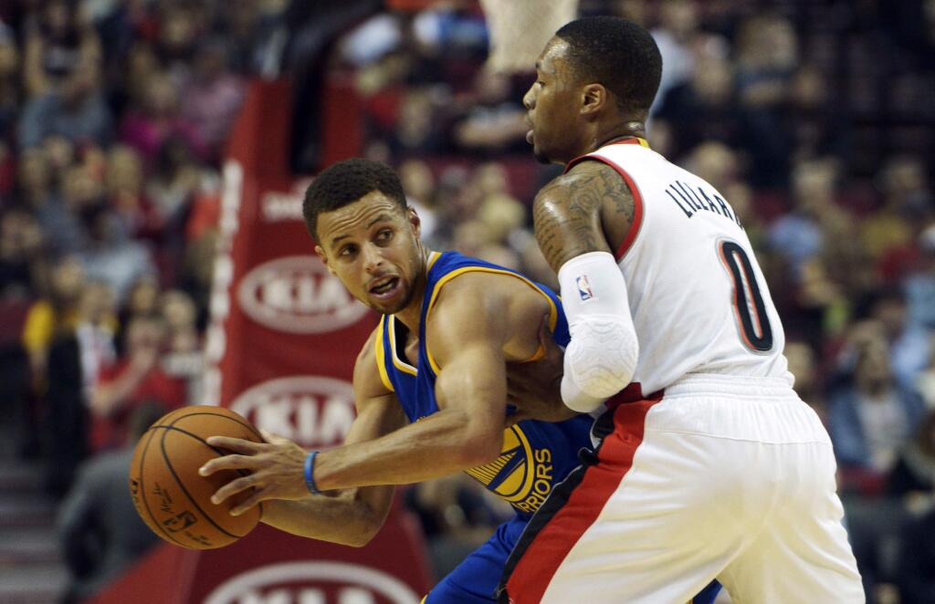 Golden State Warriors guard Stephen Curry, left, looks to pass the ball as Portland Trail Blazers guard Damian Lillard (0) defends during the first quarter in Portland, Ore., Thursday, Oct. 8, 2015. (AP Photo/Steve Dykes)