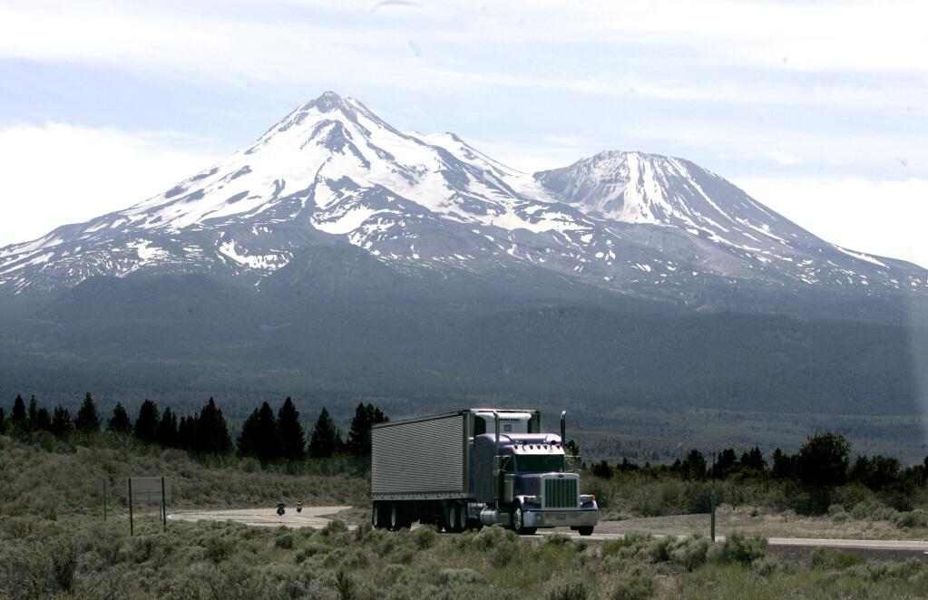 FILE -- In this June 19, 2008, file photo a truck drives past Mount Shasta near Weed, Calif. California and 14 other states are suing the Trump administration over its decision to suspend an Obama-era rule aimed at limiting pollution from trucks. The lawsuit filed Thursday, July 19, 2018, in the U.S. Court of Appeals for the District of Columbia Circuit says the July 6 decision by the Environmental Protection Agency was illegal and could put thousands of additional highly polluting trucks on the roads. (AP Photo/Rich Pedroncelli, File)