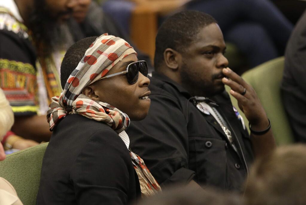 Stevante Clark, left, the brother of Stephon Clark, who was shot and killed by Sacramento police, listens as Sacramento Police Chief Daniel Hahn answers questions concerning the shooting of Clark, at a meeting of the Sacramento City Council, Tuesday, April 10, 2018, in Sacramento, Calif. Hahn told City Council members that the department is working to give new officers training and experience in avoiding implicit racial bias. (AP Photo/Rich Pedroncelli)