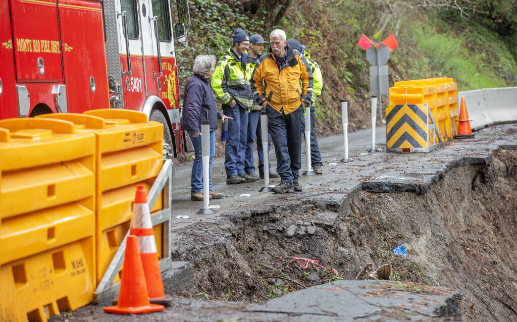 Monte Rio Fire Chief Steve Baxman, talks to resident Sukey Robb-Wilder after checking the width of the passable slide area to make sure his crews can make it through the narrow one lane road near Villa Grande, Tuesday, Feb. 28, 2023. (Chad Surmick / The Press Democrat file)