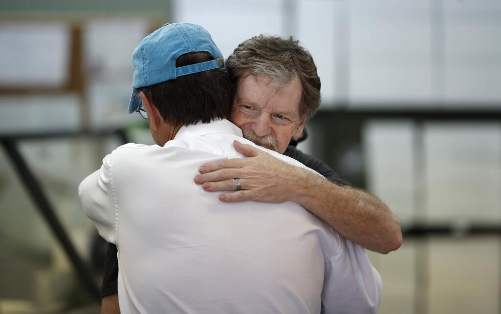 Baker Jack Phillips, owner of Masterpiece Cakeshop, left, is hugged by a man Monday, June 4, 2018, in Lakewood, Colo., after the U.S. Supreme Court ruled that he could refuse to make a wedding cake for a same-sex couple because of his religious beliefs did not violate Colorado's anti-discrimination law. (AP Photo/David Zalubowski)