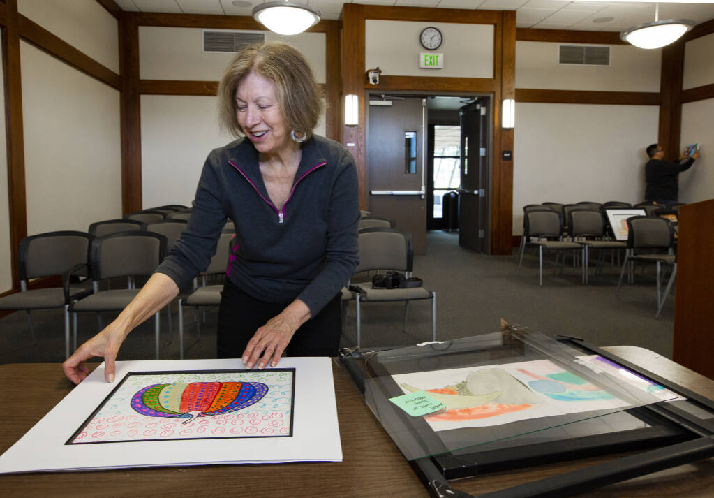 Connie Schlelein, a member of the Sonoma Cultural and Fine Arts Commission, curating students’ artwork for hanging in the City Council Chambers on First St. W. on Monday, March 13. (Robbi Pengelly/Index-Tribune)
