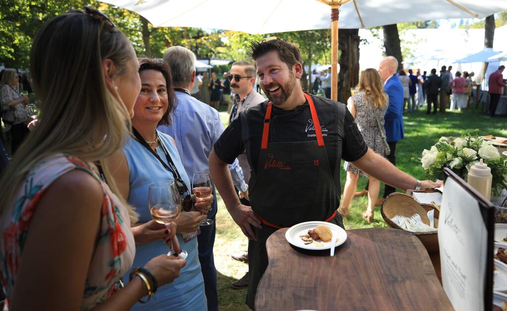 Restaurant owner Dustin Valette greets friends prior to the Sonoma County Wine Auction at La Crema Estate at Saralee's Vineyard in Windsor, Saturday, Sept. 21, 2019. (Kent Porter / The Press Democrat