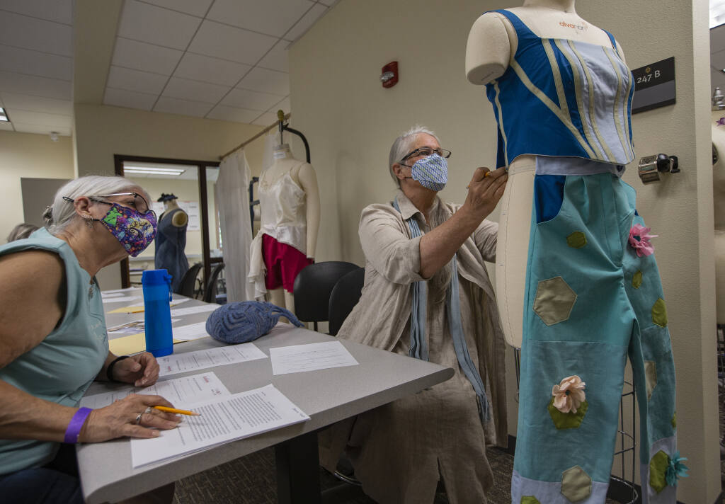 Judges Eddie Edler, and Robyn Spencer-Crompton inspect sustainable and recycled fashions at the SRJC Petaluma campus Fashion Lab during judging for an upcoming show featuring the work of student designers. May 4, 2022. (Chad Surmick / The Press Democrat)