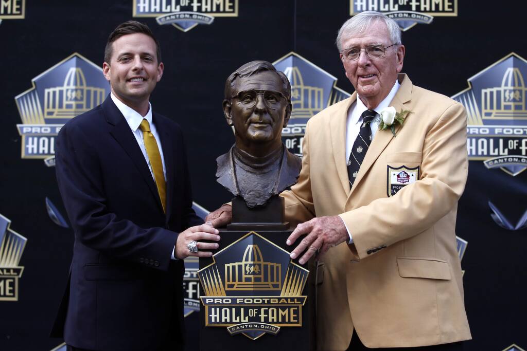 Former NFL contributor Ron Wolf, right, poses with a bust of himself and presenter, son, Eliot Wolf, during an induction ceremony at the Pro Football Hall of Fame, Saturday, Aug. 8, 2015 in Canton, Ohio. (AP Photo/Gene J. Puskar)