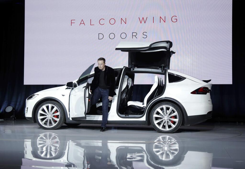 Elon Musk, CEO of Tesla Motors Inc., introduces the Model X car at the company's headquarters Tuesday, Sept. 29, 2015, in Fremont, Calif. Musk said the Model X sets a new bar for automotive engineering, with unique features like rear falcon-wing doors, which open upward, and a driver's door that opens on approach and closes itself when the driver is inside. (AP Photo/Marcio Jose Sanchez)