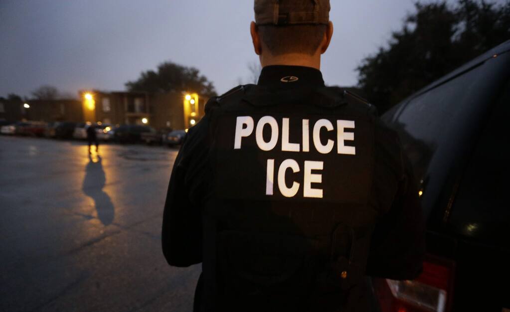 FILE - In this March 6, 2015, file photo, U.S. Immigration and Customs Enforcement agents enter an apartment complex looking for a specific undocumented immigrant convicted of a felony during an early morning operation in Dallas. The federal government provided Tuesday, Dec. 5, 2017, the most complete statistical snapshot of immigration enforcement under President Donald Trump, showing Border Patrol arrests plunged to a 45-year low while arrests by deportation officers soared. (AP Photo/LM Otero, File)