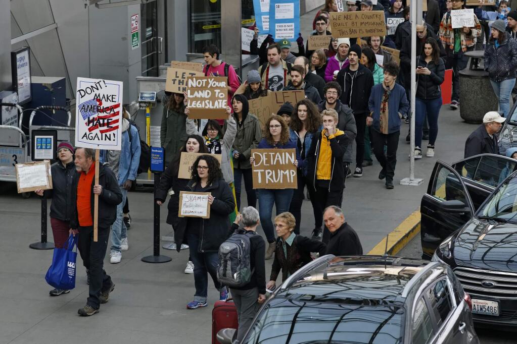 Dozens of demonstrators marched in and around the main terminal at Portland International Airport, to protest President Donald Trump's order restricting immigration into the U.S., Saturday, Jan. 28, 2017, in Portland, Ore. (Mike Zacchino/The Oregonian via AP)