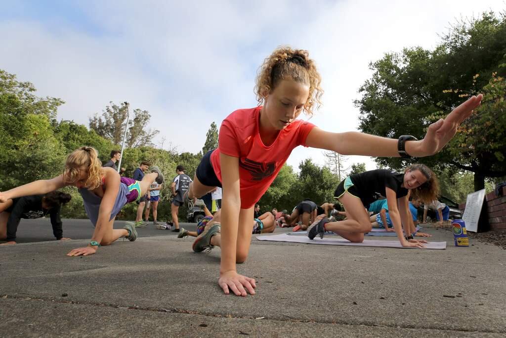 Bria Keelty does strength training exercises with her teammates during a Santa Rosa Junior College cross country practice in Santa Rosa on Wednesday, Aug. 7, 2019. (BETH SCHLANKER / The Press Democrat)