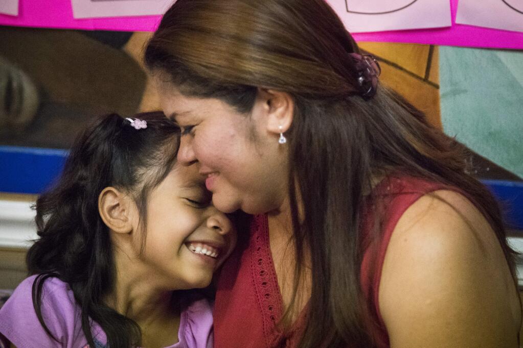 FILE - In this July 13, 2018, file photo, Allison, 6, and her mother Cindy Madrid share a moment during a news conference in Houston, where the mother and daughter spoke about the month and one day they were separated under the President Donald Trump administration immigration policy. The Trump administration is due back in court Monday, July 16, 2018, to discuss a plan reunify more than 2,500 children who were separated at the border from their parents. (Marie D. De Jes's/Houston Chronicle via AP, File)