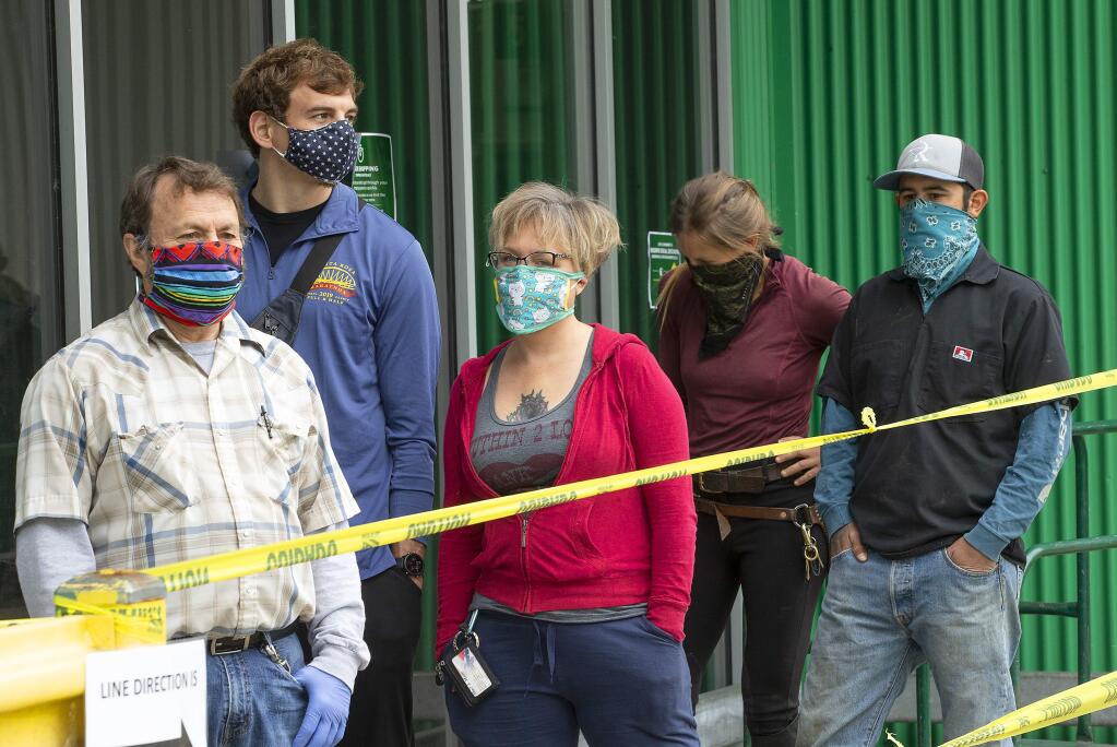 Shoppers wearing fashionable face masks wait in line at Friedman's Home Improvement in Santa Rosa on Friday, April 17, 2020. ( John Burgess/The Press Democrat)