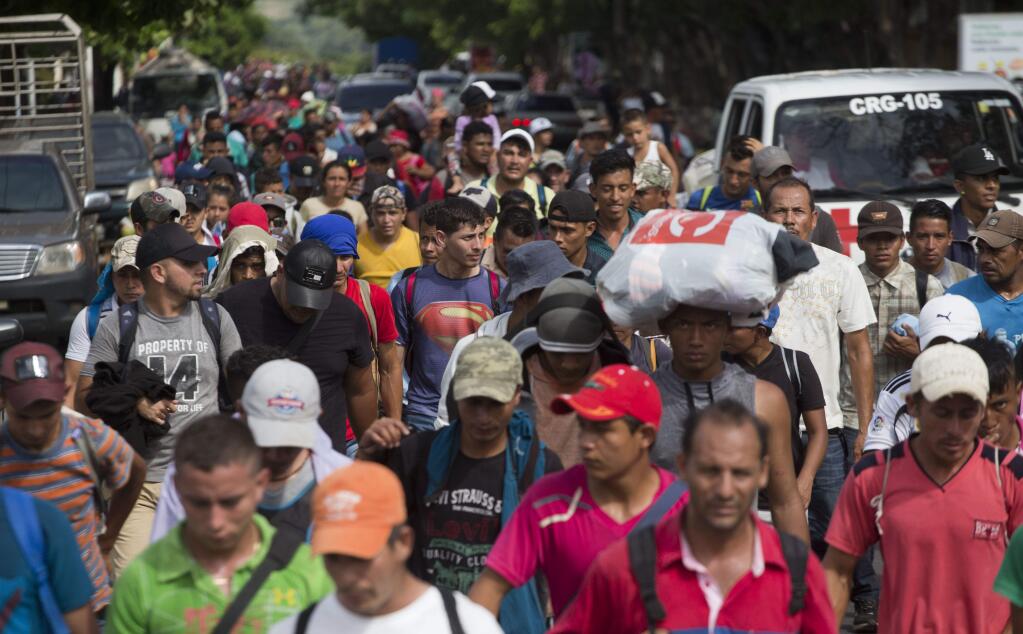Honduran migrants walk toward the U.S. as they arrive at Chiquimula, Guatemala, Tuesday, Oct. 16, 2018. U.S. President Donald Trump threatened on Tuesday to cut aid to Honduras if it doesn't stop the impromptu caravan of migrants, but it remains unclear if governments in the region can summon the political will to physically halt the determined border-crossers. (AP Photo/Moises Castillo)