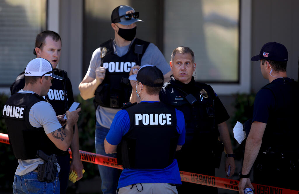 Rohnert Park Department of Public Safety officers discuss their next steps at the scene of a shooting that left one person dead, Friday, June 4, 2021 at Park Ridge Apartments along Snyder Lane in Rohnert Park. (Kent Porter / The Press Democrat) 2021
