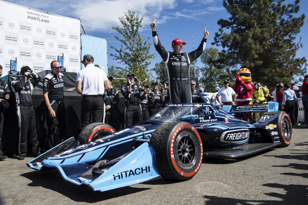 Scott McLaughlin raises his arms in victory at the Grand Prix of Portland IndyCar auto race at the Portland International Raceway in Portland, Ore., on Sunday, Sept. 4, 2022. (Naji Saker/The Oregonian via AP)