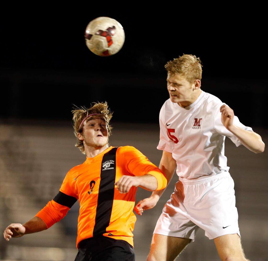 Santa Rosa's Seamus Young (9), left, and Montgomery's Jordan Secchitano (15) compete for a header during the first half of a boys varsity soccer match between Santa Rosa and Montgomery high schools in Santa Rosa, California on Wednesday, February 10, 2016. (Alvin Jornada / The Press Democrat)