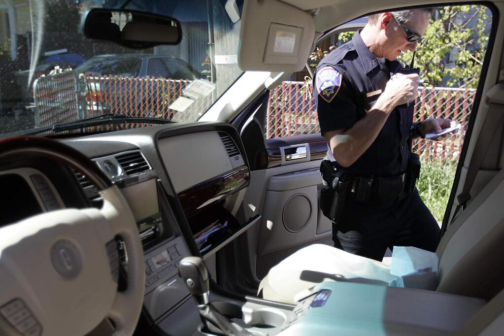 Santa Rosa Police Officer Greg Yaeger checks the information on a vehicle during a traffic stop on an unlicensed driver on Thursday, March 26, 2009.