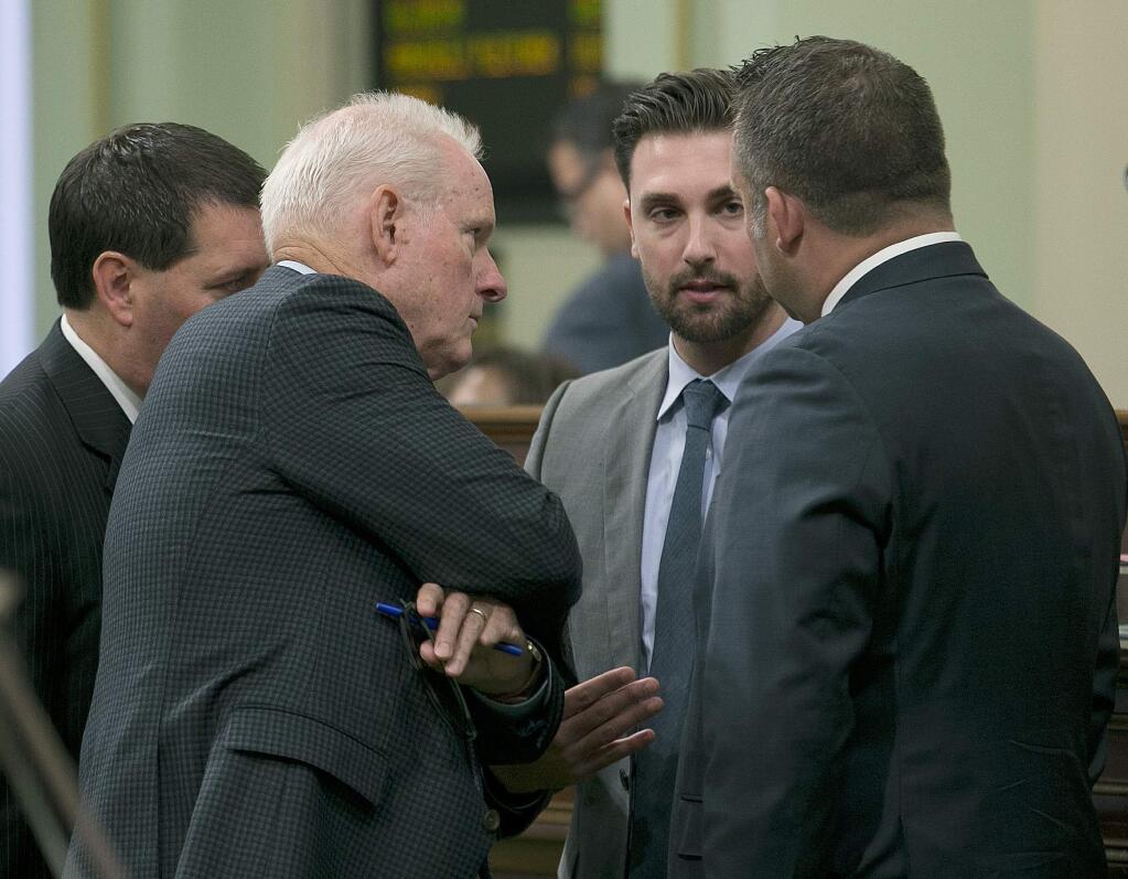 Democratic Assembly members, from left, Tim Grayson, of Concord, Tom Daly, of Anaheim, Ian Caldron, of Whittier, and Adam Gray of Merced, huddle during the Assembly session, Wednesday, Sept. 13, 2017, in Sacramento, Calif. Lawmakers are working to complete this years legislative business to meet the Friday, Sept. 15 deadline. (AP Photo/Rich Pedroncelli)