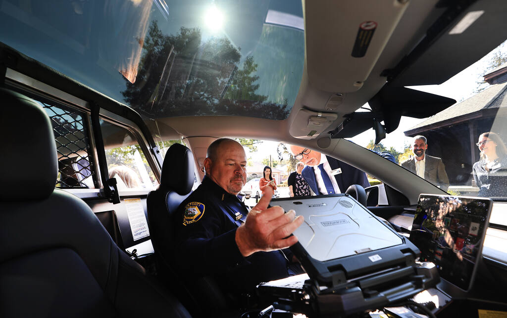A sunroof illuminates Cotati police chief Michael Parish as he prepares to start a Tesla electric vehicle, that will be used in the Cotati Police Department patrol fleet, Thursday, Sept. 15, 2022.   (Kent Porter / The Press Democrat) 2022
