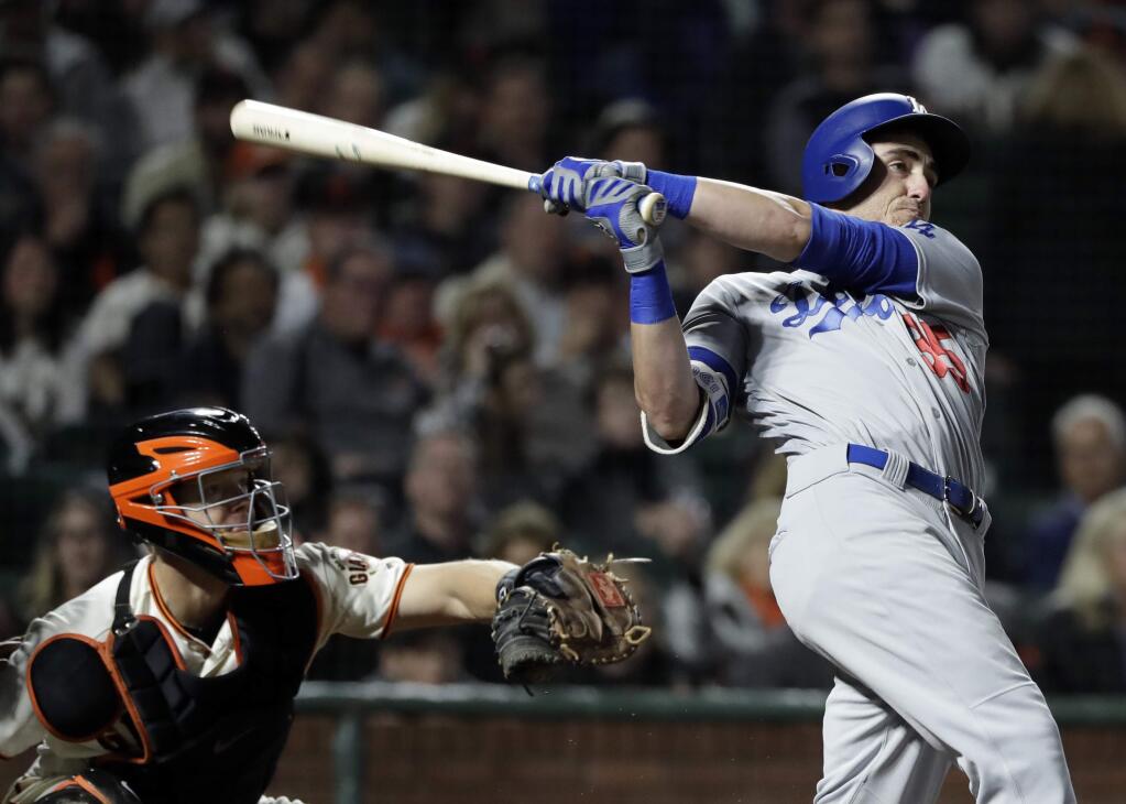 FILE - In this Sept. 13, 2017, file photo, Los Angeles Dodgers' Cody Bellinger follows through on a two-run home run against the San Francisco Giants during the fifth inning of a baseball game, in San Francisco. Nearly two decades after the height of the Steroids Era, Major League Baseball is on track to break its season record for home runs on Tuesday with nearly two weeks left in the season. There were 5,663 home runs hit through Sunday, 30 shy of the record 5,693 set in 2000. (AP Photo/Marcio Jose Sanchez, File)