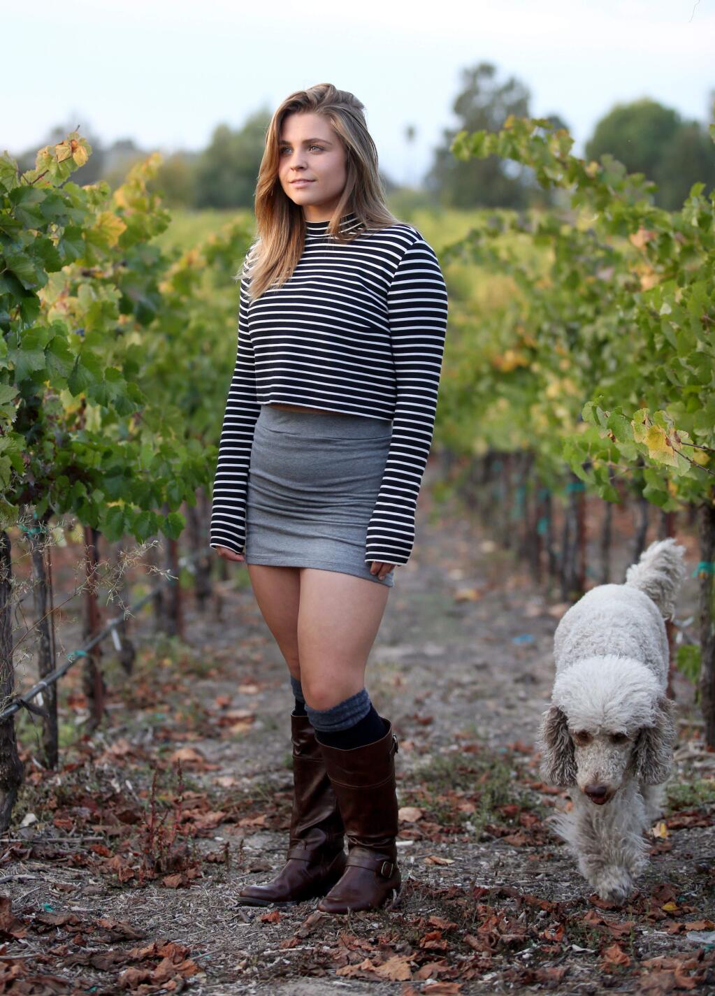 Sunce Franicevic, 16, a senior at Santa Rosa High School, stands with her dog Sadie in her families winery, Sunce Winery, named after her, Monday, September 29, 2014. (Crista Jeremiason / The Press Democrat)