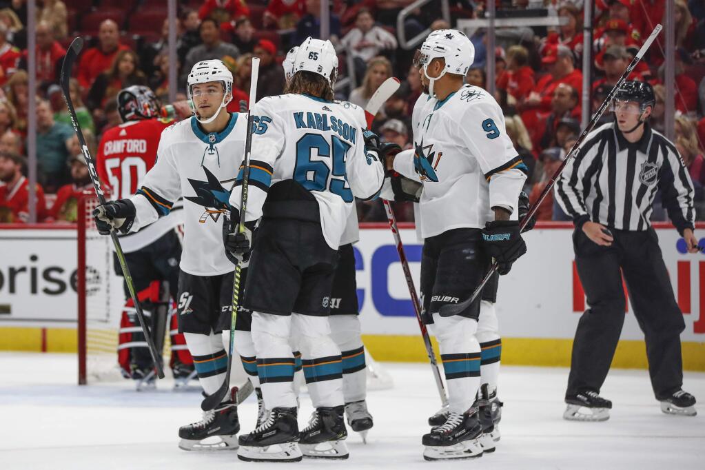 San Jose Sharks right wing Kevin Labanc, left, celebrates with teammates after scoring against the Chicago Blackhawks during the first period of an NHL hockey game Thursday, Oct. 10, 2019, in Chicago. (AP Photo/Kamil Krzaczynski)