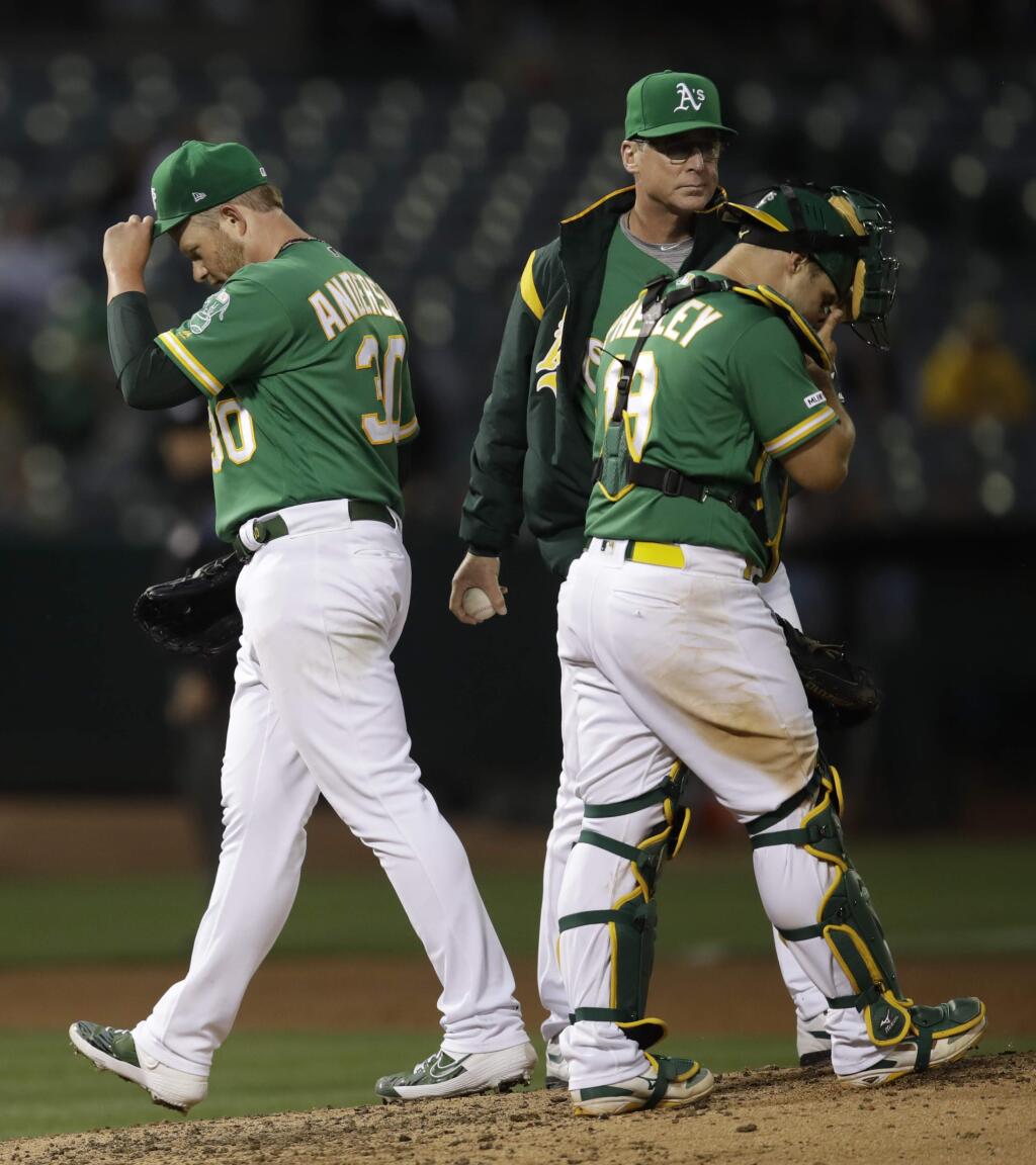Oakland Athletics pitcher Brett Anderson, left, walks off the mound after being relieved by manager Bob Melvin, center, in the fifth inning against the Texas Rangers, Thursday, July 25, 2019, in Oakland. At right is A's catcher Josh Phegley. (AP Photo/Ben Margot)