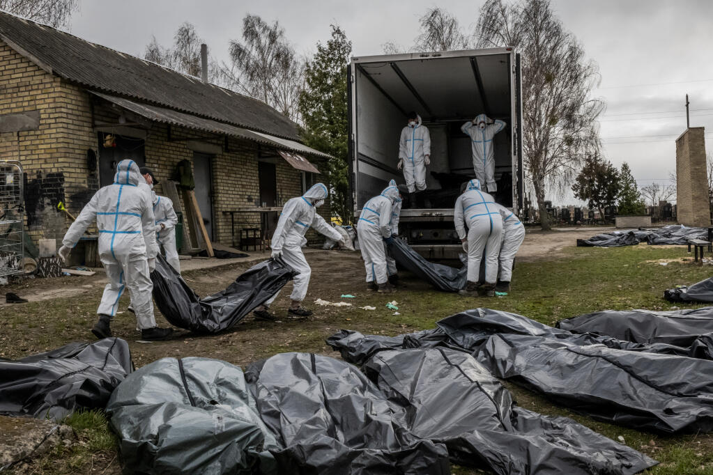 Volunteer cemetery workers load a large truck with 65 bodies to be taken for further forensic investigation in Bucha, Ukraine, April 12, 2022. Lyudmyla Denisova, Ukraine's human rights commissioner, has been working in overdrive since Russian troops invaded in February, identifying, documenting and bearing witness to human rights violations. (Daniel Berehulak/The New York Times)