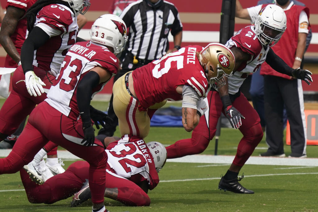 San Francisco 49ers tight end George Kittle is tackled by Arizona Cardinals strong safety Budda Baker, on ground, during the first half in Santa Clara, Sunday, Sept. 13, 2020. (Tony Avelar / ASSOCIATED PRESS)